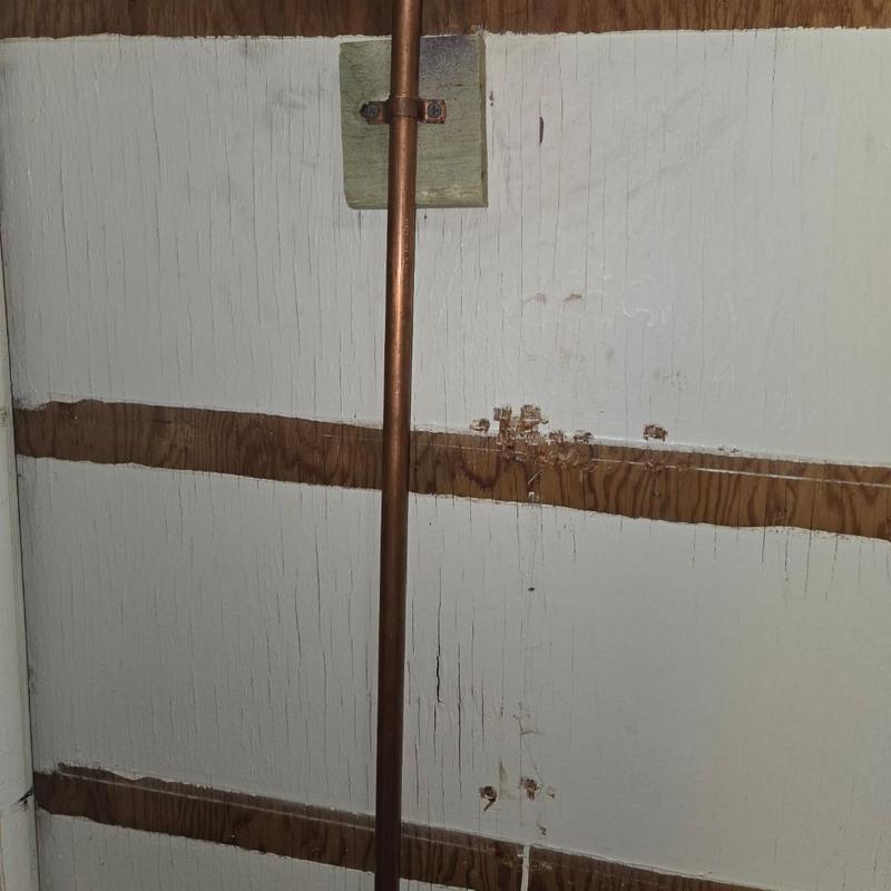Copper water pipe mounted on interior wall with brackets
