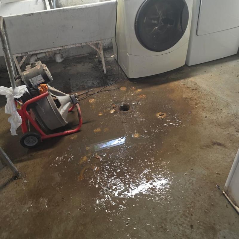 Main sewer line cleanout with plumbing snake machine
