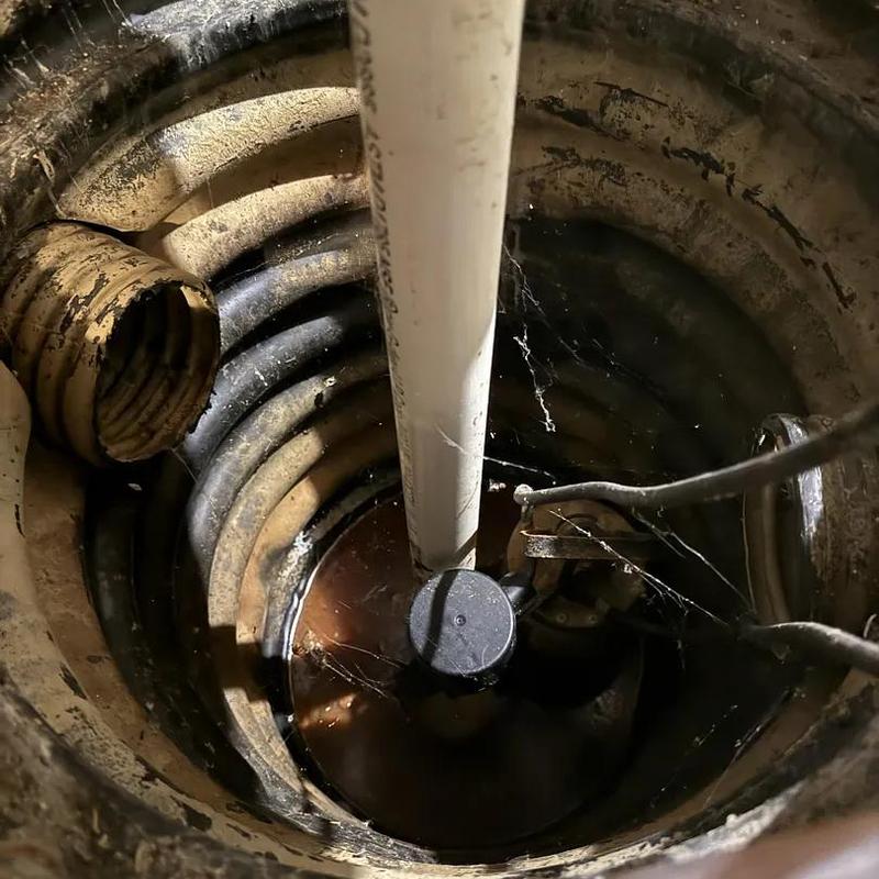Sump pump basket inside underground pit with pipes