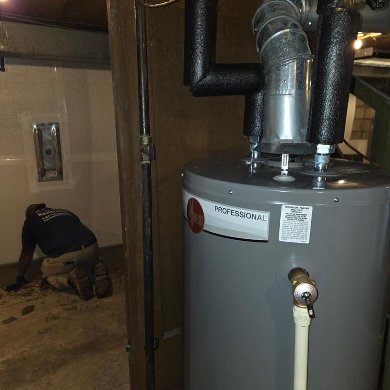 Water heater with insulation and plumbing repair in basement
