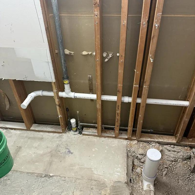 PVC plumbing rough-in with wall studs exposed