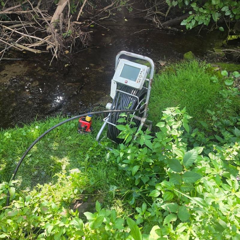 Storm drain camera inspection near creek and vegetation