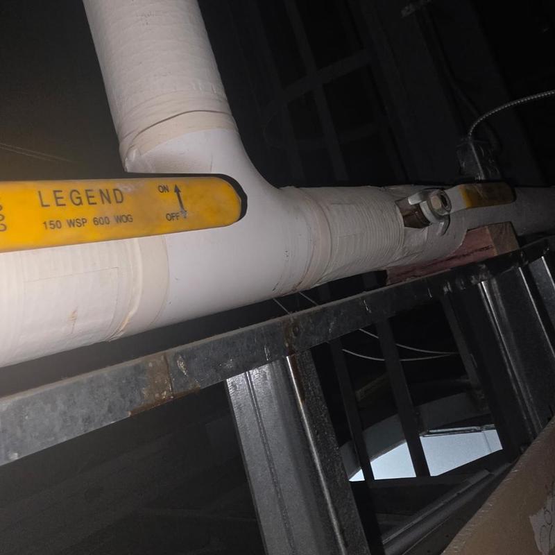 Bathroom isolation valve on white pipe in ceiling
