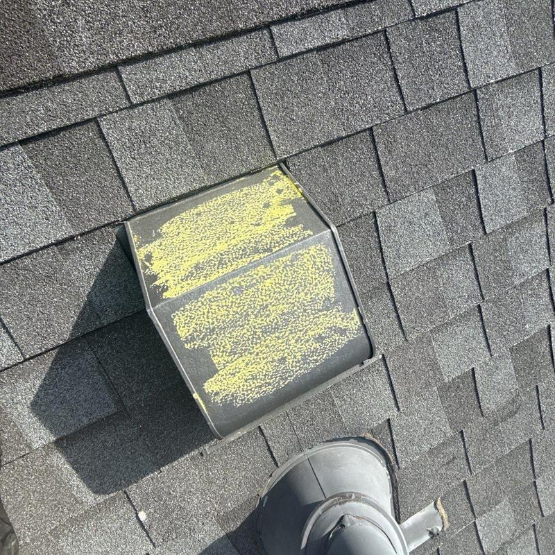 Roof vent with hail damage markings on shingles