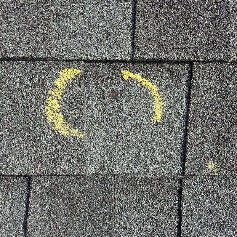 Roof shingles with marked hail damage spots