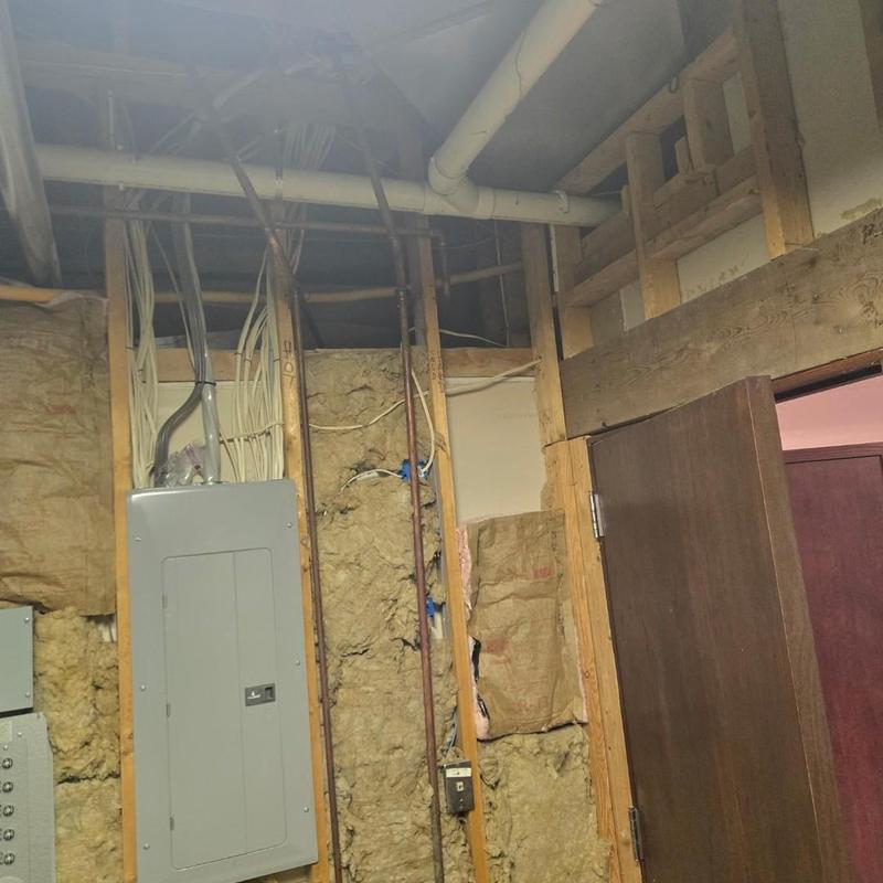 Electrical panel with wiring in unfinished wall space