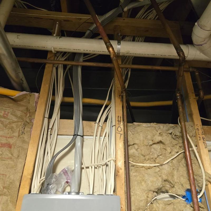 Electrical wiring and plumbing pipes in wall cavity