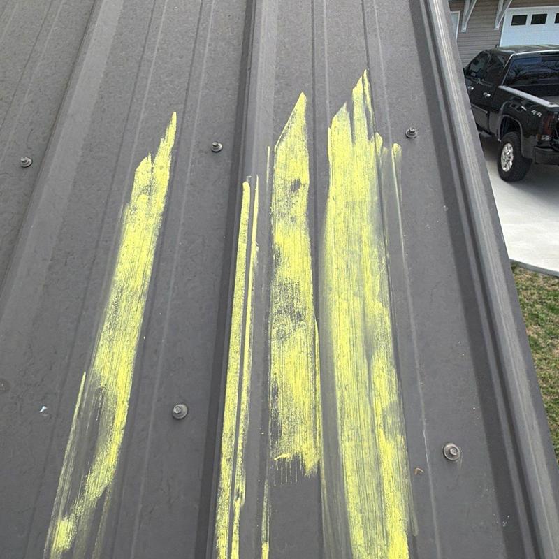 Metal roof panel with yellow chalk hail damage marks