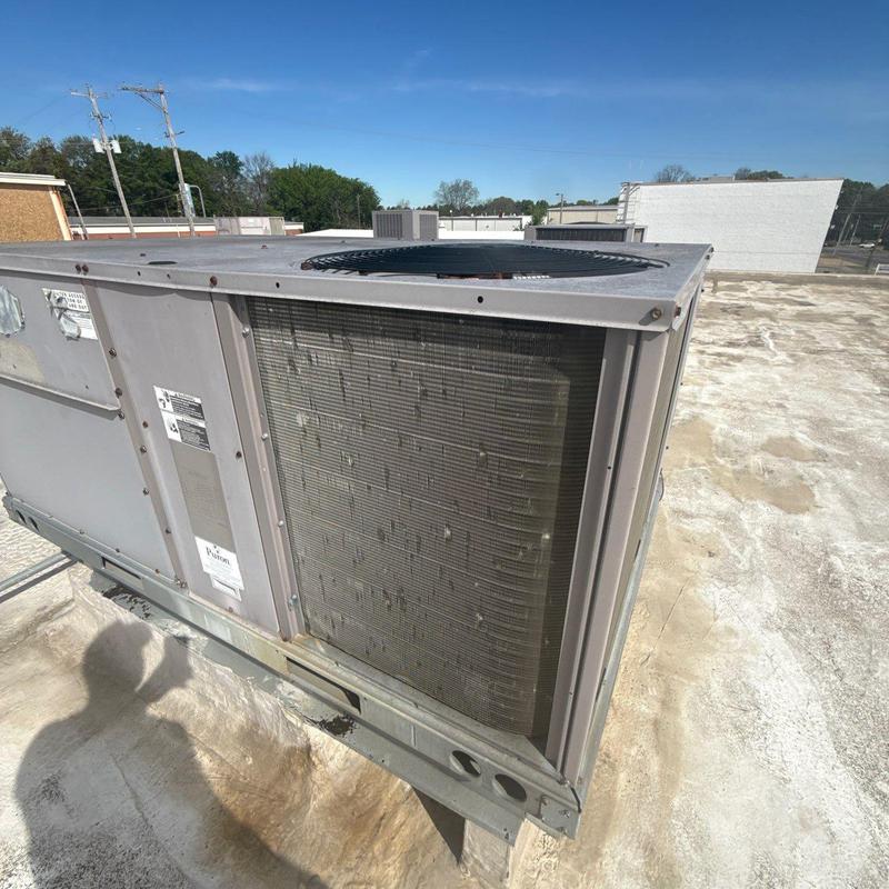 Commercial rooftop HVAC unit showing external coil damage