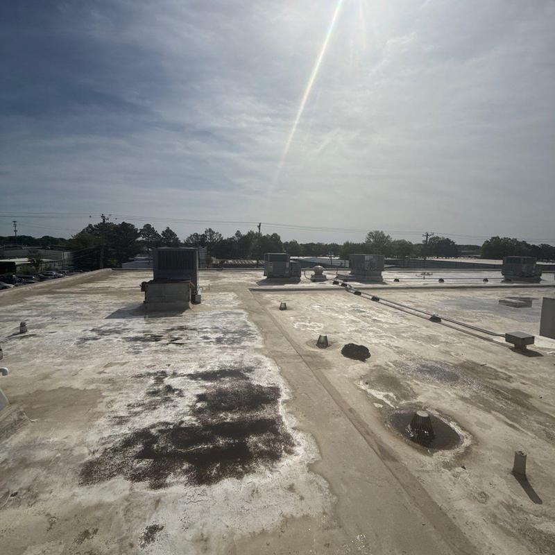 Commercial flat roof with hail damage and HVAC units