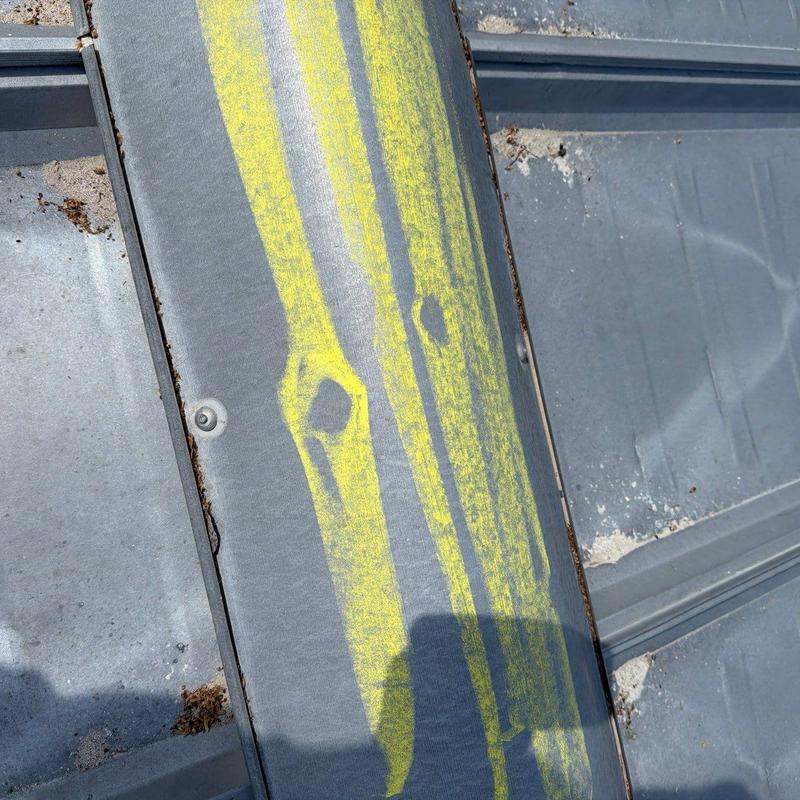 Metal roofing panel marked for hail damage inspection