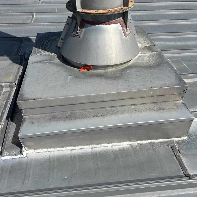 Metal roof vent flashing with sealant on metal roof