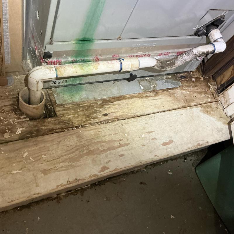 AC drain pipe with corrosion and wood damage