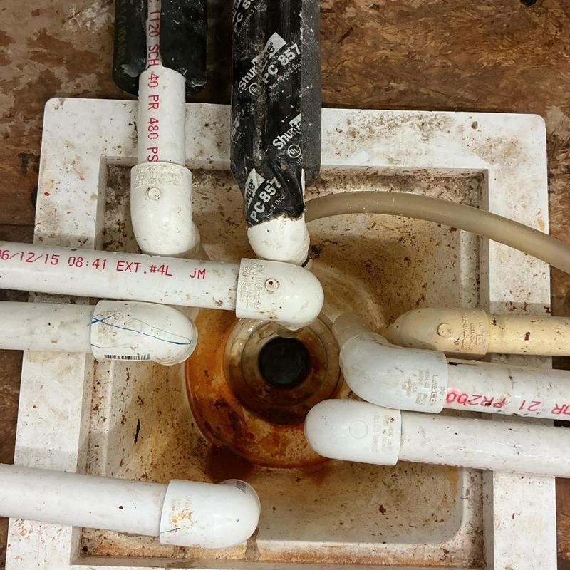 PVC drain pipes with elbow joints and debris buildup