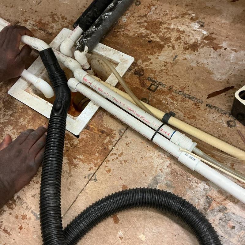 PVC drain pipes with vacuum hose clearing debris