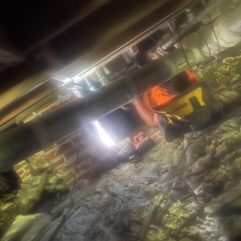 Sewer pipe repair in crawl space with toolbox Sewer pipe repair in crawl space with toolbox