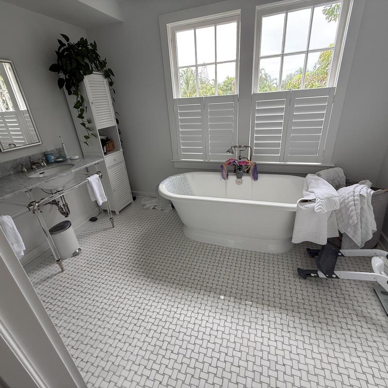 Bathtub faucet and drain with towels in bathroom
