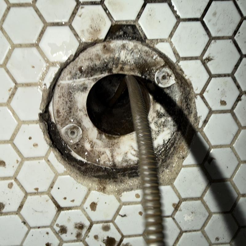Floor drain main line cleaning with snake tool on tile floor Floor drain main line cleaning with snake tool on tile floor