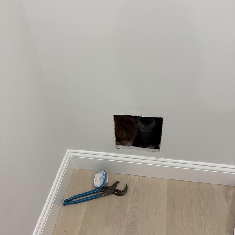 Drain pipe with opening in wall and plumbing wrench Drain pipe with opening in wall and plumbing wrench