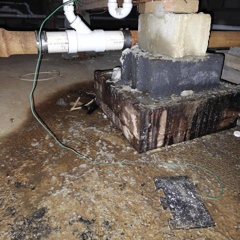 Laundry drain line with water damage on floor and foundation block Laundry drain line with water damage on floor and foundation block