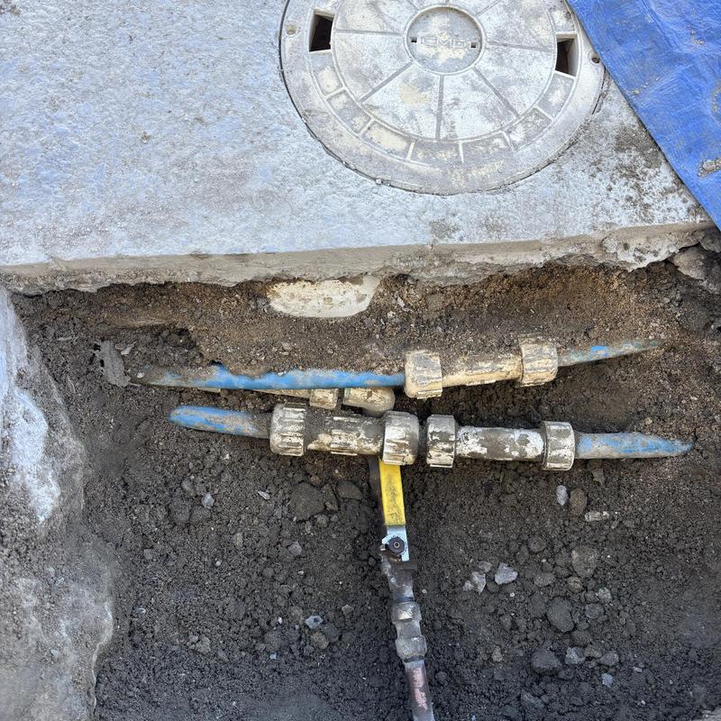 Pool water valve with blue PVC piping exposed in soil Pool water valve with blue PVC piping exposed in soil