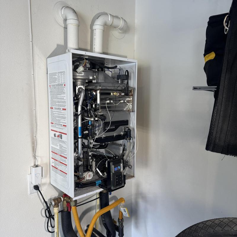 Navien heat exchanger unit with open panel and pipes Navien heat exchanger unit with open panel and pipes