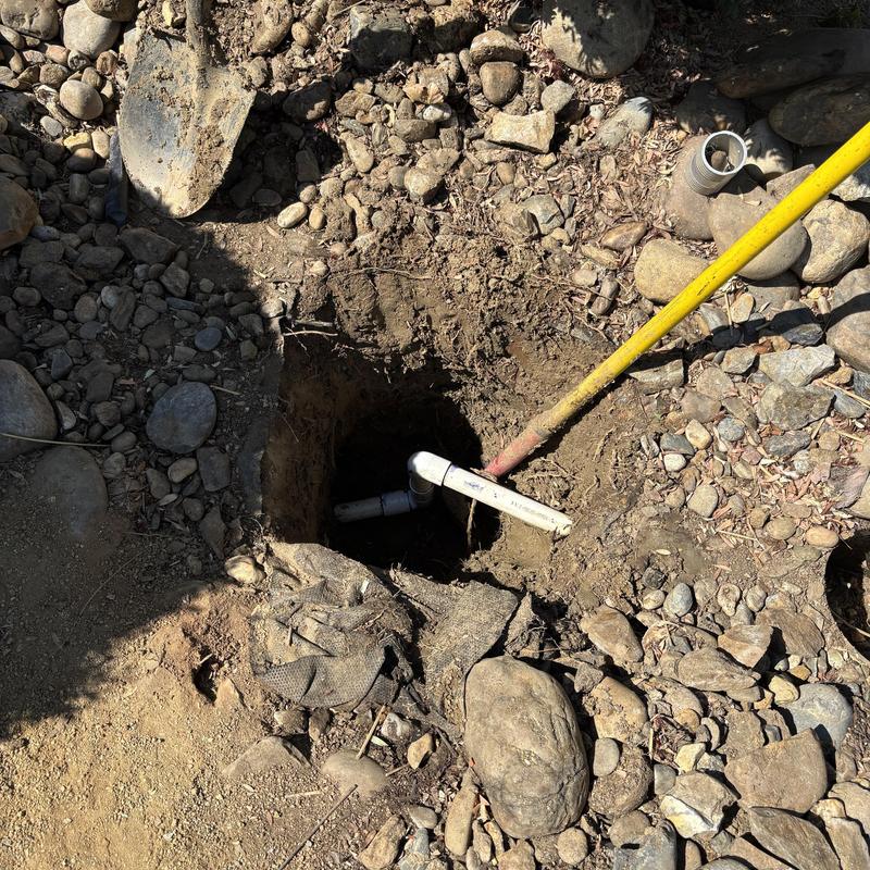 Main water service line exposed in rocky soil hole Main water service line exposed in rocky soil hole
