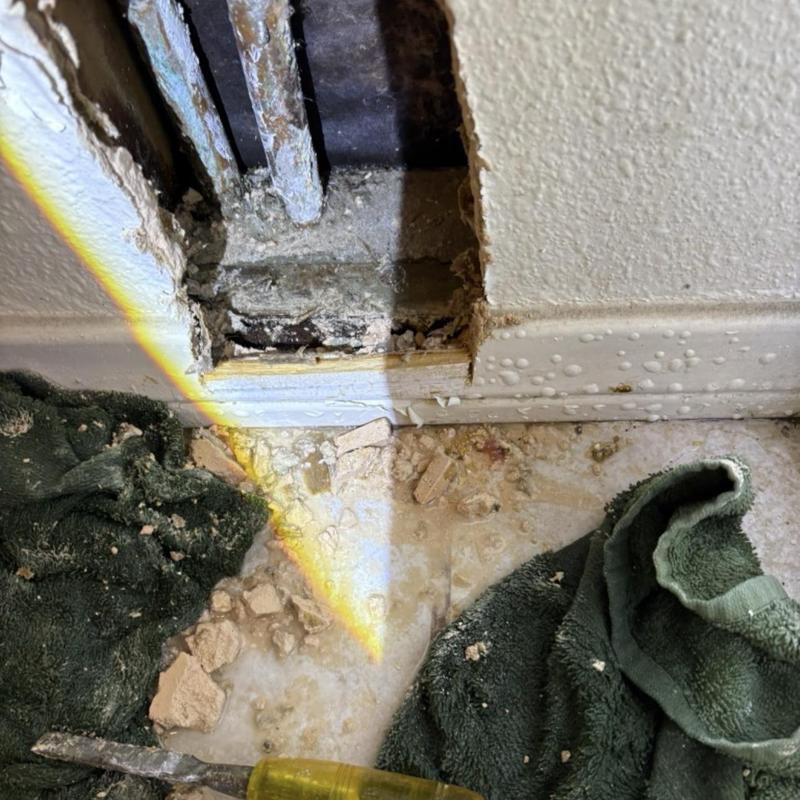 Water supply pipes inside wall with debris and towel Water supply pipes inside wall with debris and towel