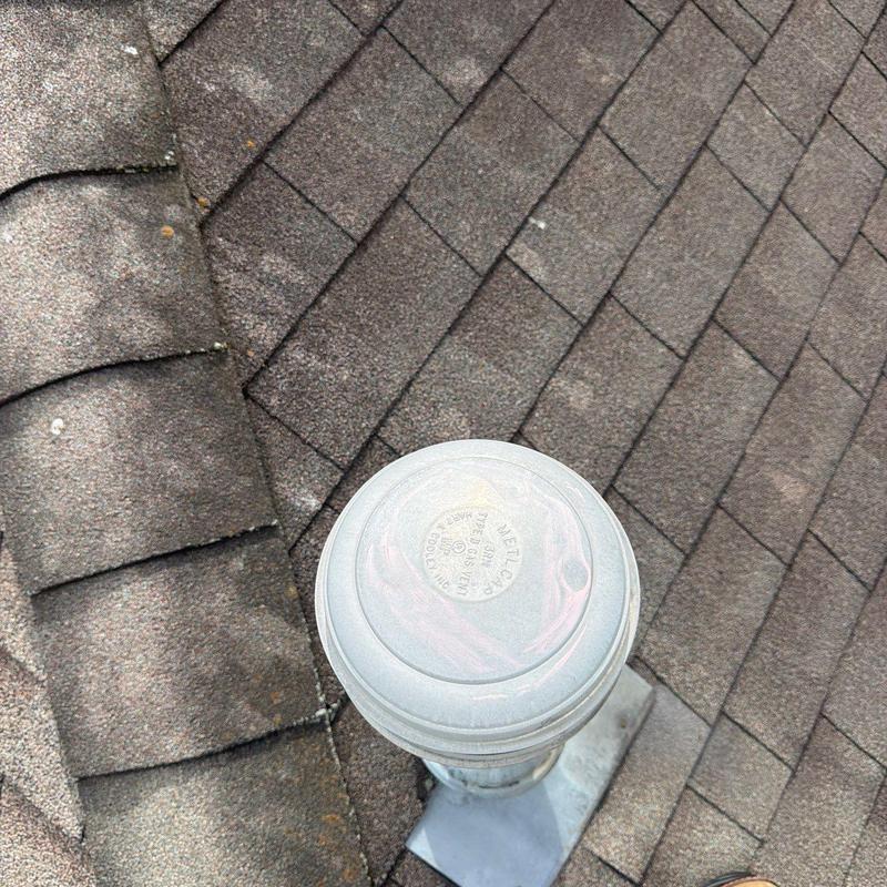 Roof vent pipe on shingle roof with hail damage