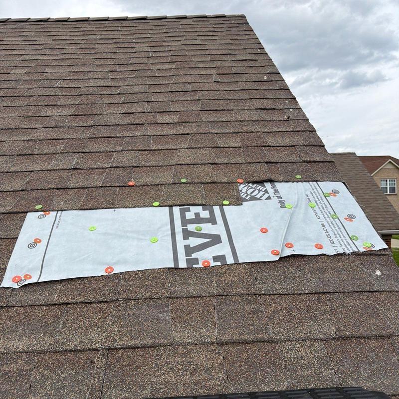 Asphalt shingle roof with hail damage and repair patch