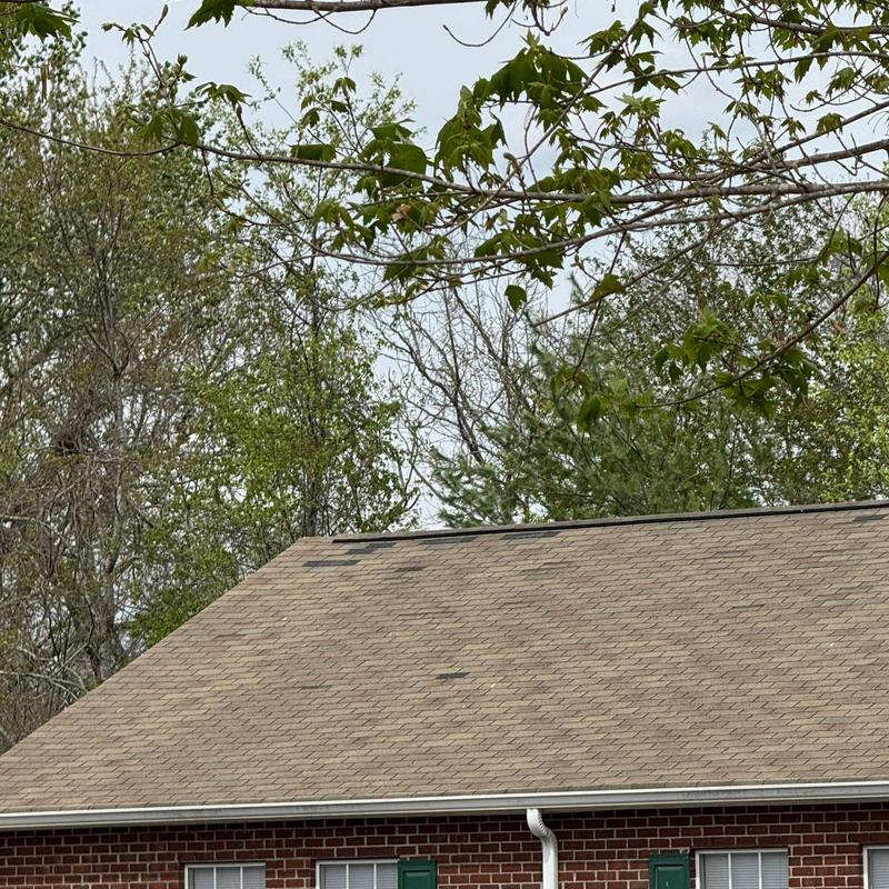 Asphalt shingle roof with visible hail damage patches