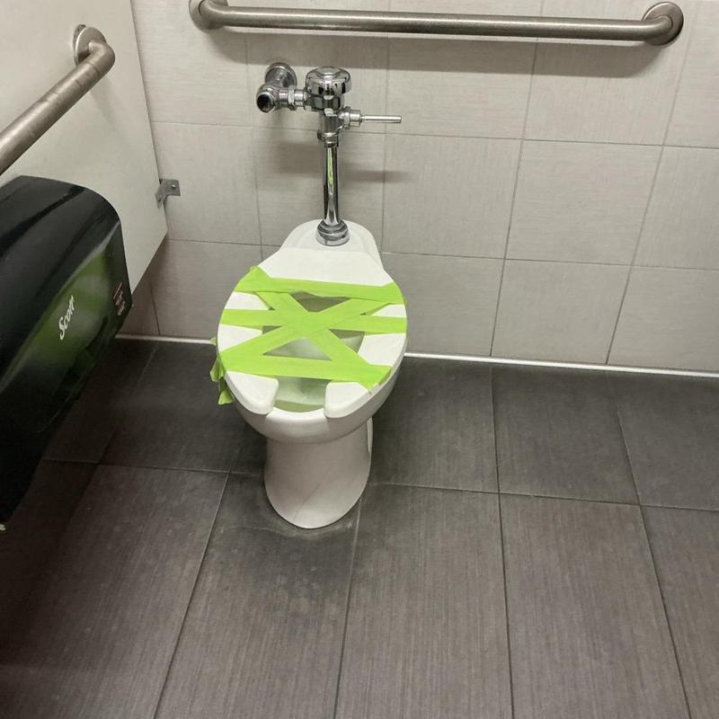 ADA-compliant toilet with flush valve taped shut