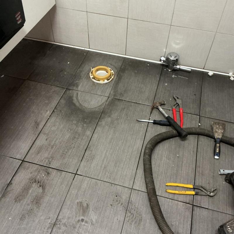 ADA-compliant toilet flange and plumbing tools on floor