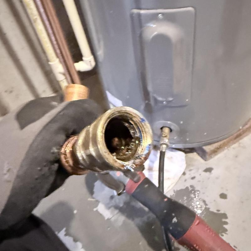 Water heater leak fitting replacement with tool in hand Water heater leak fitting replacement with tool in hand