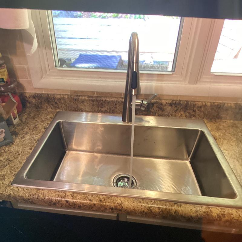 Stainless steel kitchen sink with running faucet