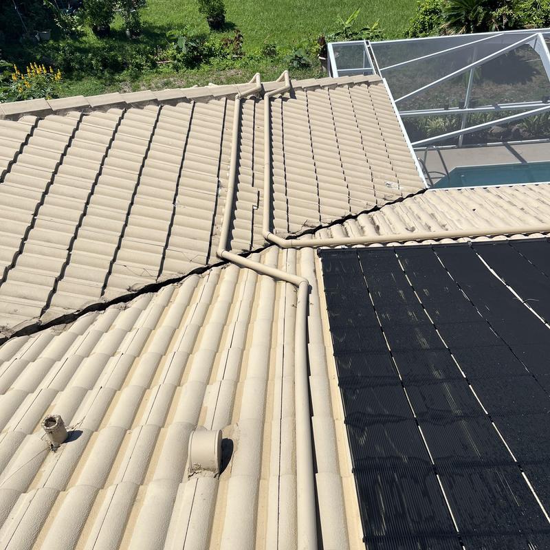 Tile roof valley with solar panel and vent pipes Tile roof valley with solar panel and vent pipes