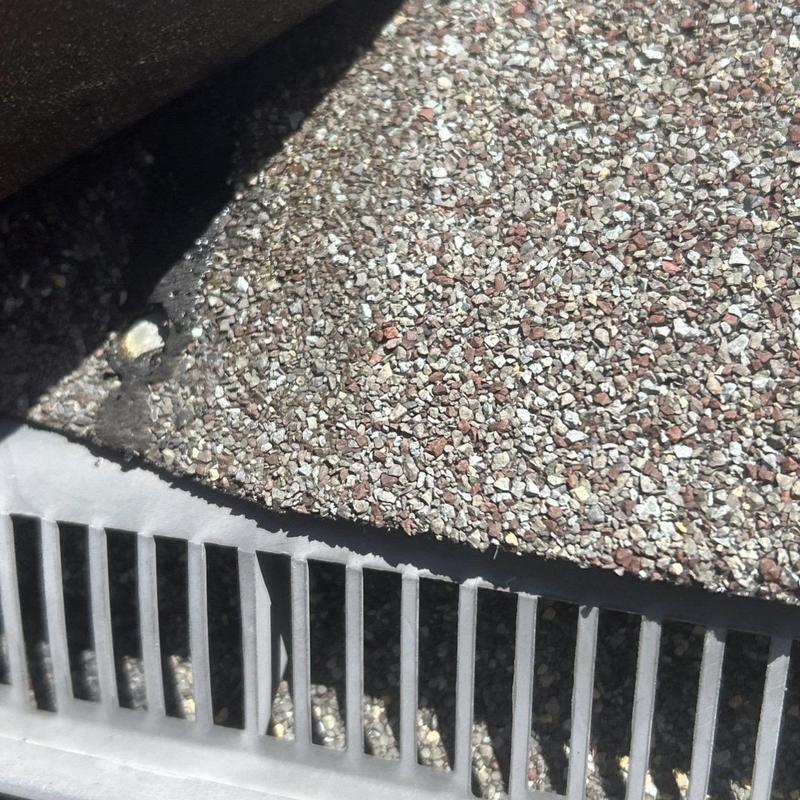 Roof shingles and metal ridge vent close-up inspection