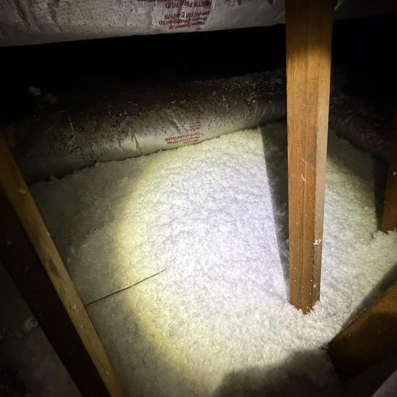 Attic loose-fill insulation with wooden framing and ductwork