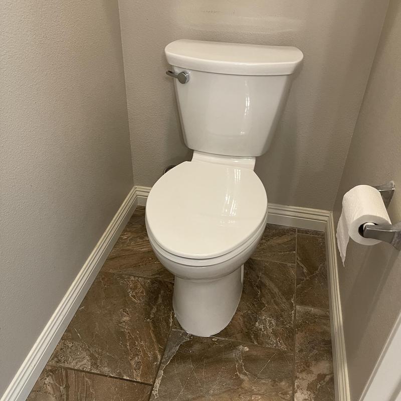 Standard toilet installed in small bathroom nook Standard toilet installed in small bathroom nook