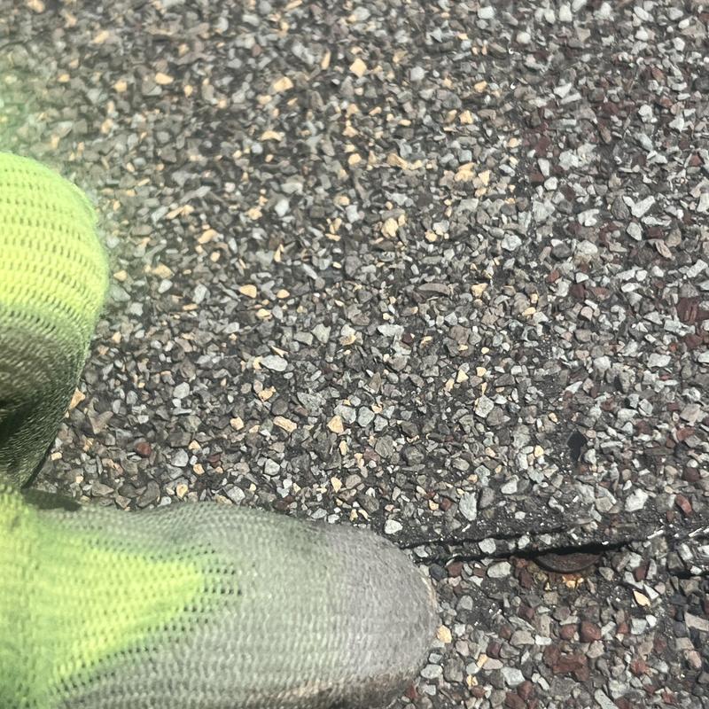 Asphalt shingle roof with visible crack and glove Asphalt shingle roof with visible crack and glove
