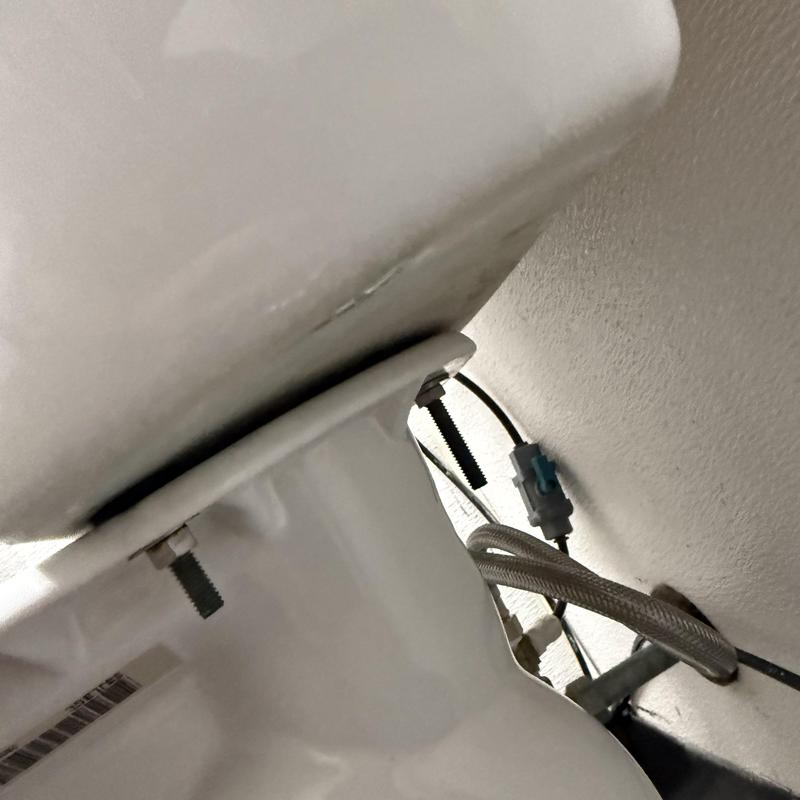 Toilet water supply line and mounting bolts close-up