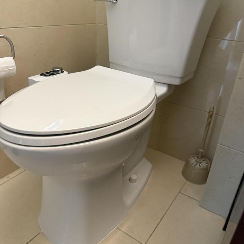 Toilet with closed lid in bathroom corner