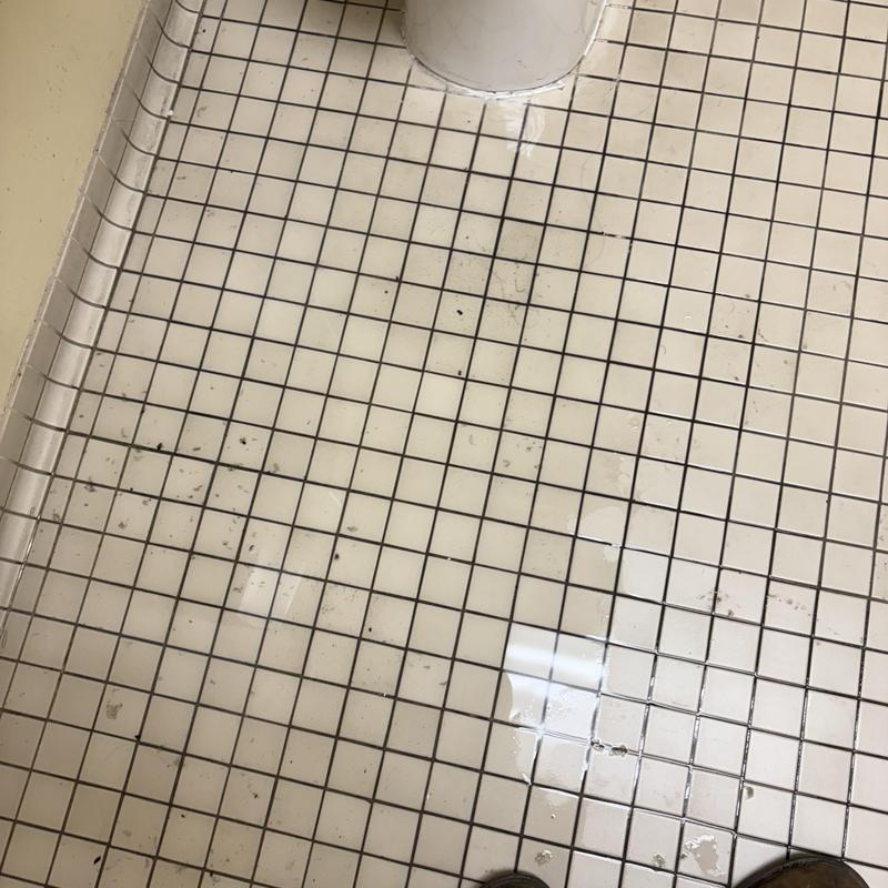 Toilet flange and tiled floor with plumbing debris Toilet flange and tiled floor with plumbing debris