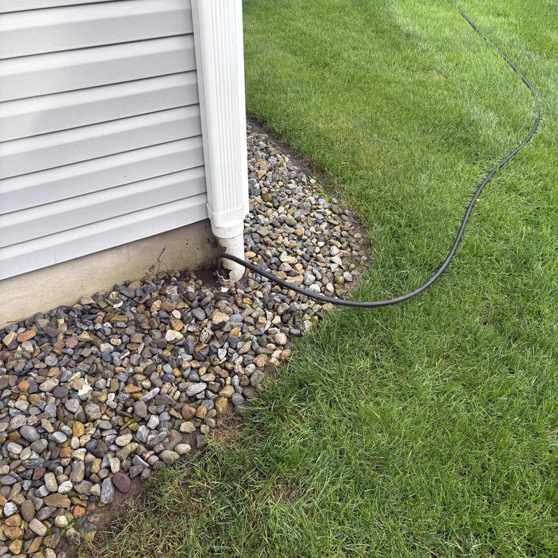 Drainpipe jetting hose inserted in exterior downspout area Drainpipe jetting hose inserted in exterior downspout area