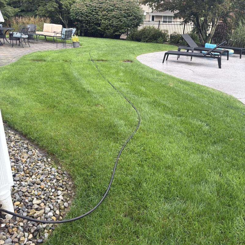 Jetting hose on residential lawn near patio furniture Jetting hose on residential lawn near patio furniture
