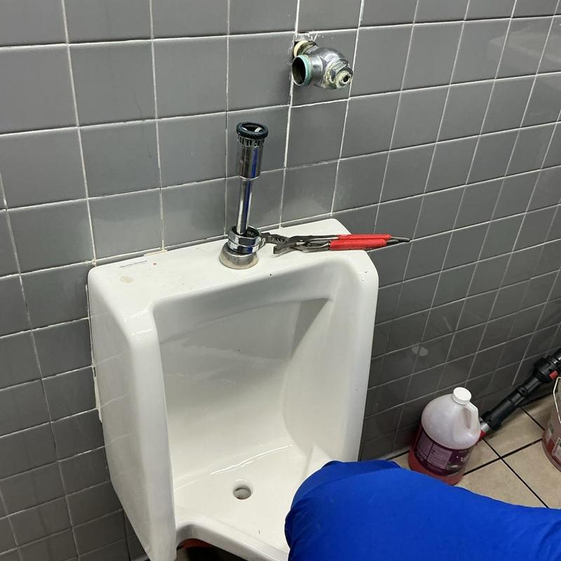 Urinal drain line with plumbing tools and chemicals