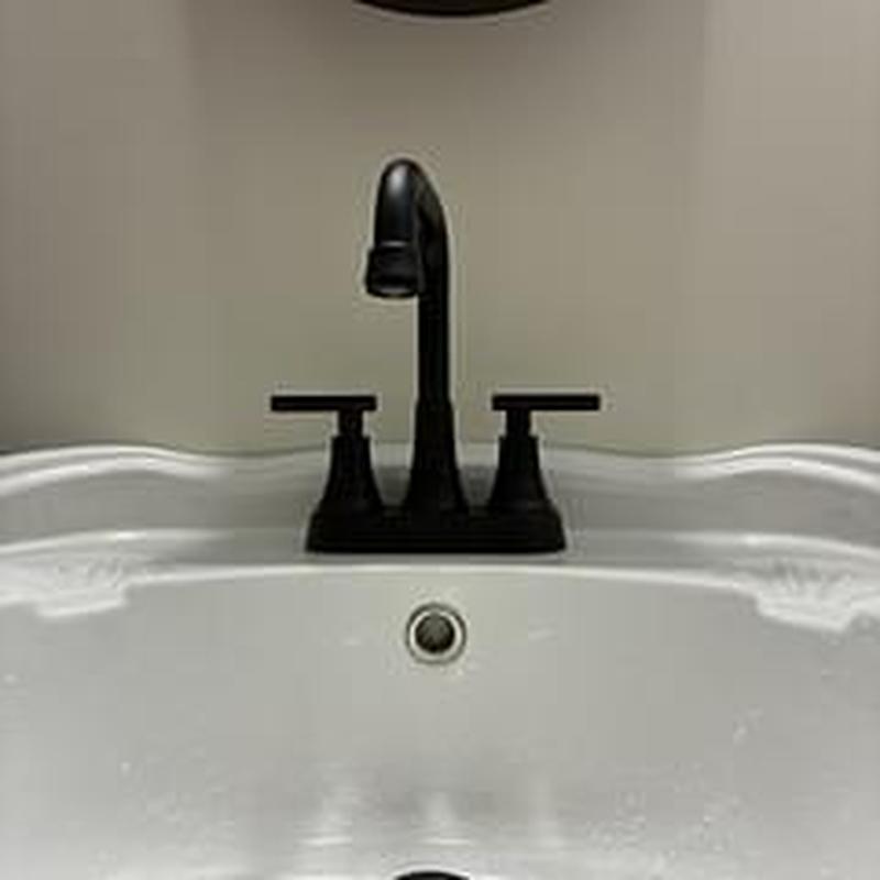 Lavatory faucet installation on white sink basin Lavatory faucet installation on white sink basin
