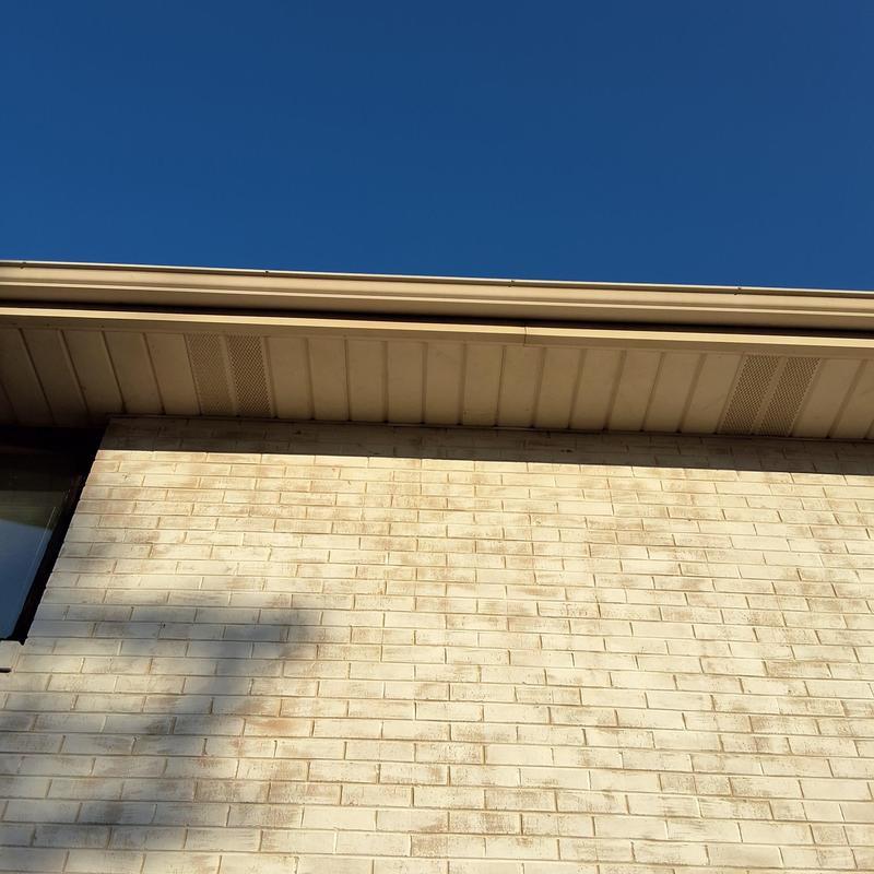 Soffit vents for attic ventilation on brick house exterior Soffit vents for attic ventilation on brick house exterior