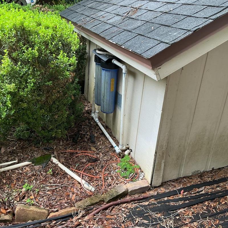 Water filtration system with piping outside shed