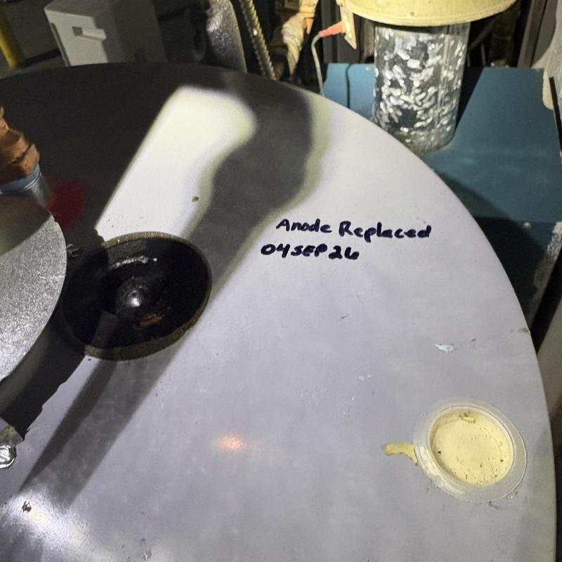 Water heater top with anode replaced and dated label